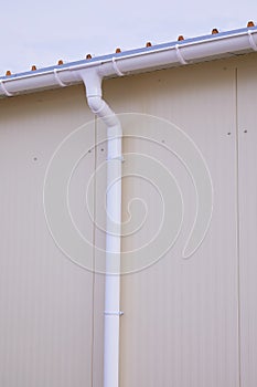 White plastic rain guttering system. Guttering drainage pipe exterior.