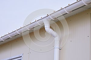 White plastic rain guttering system. Guttering drainage pipe exterior.