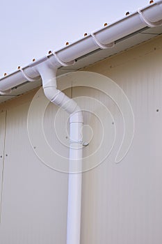 White plastic rain guttering system. Guttering drainage pipe exterior.