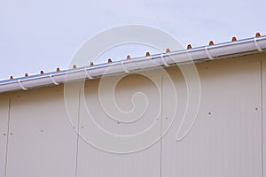 White plastic rain guttering system. Guttering drainage pipe exterior.
