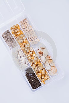 White plastic seed box container with grain seeds.