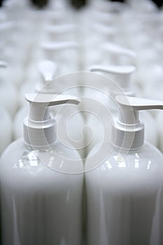 White plastic soap bottles in rows assembly line photo