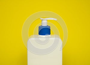 White plastic soap or shampoo dispenser pump bottle isolated on blue background. Skin care lotion. Bathing essential