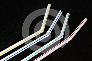 White plastic straws with colored stripes, polluting material
