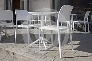 white plastic tables and chairs in a street cafe