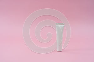 White plastic tube on pink background. Ð¡osmetic bottles for beauty or medicine products