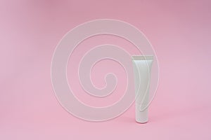 White plastic tube on pink background. Ð¡osmetic bottles for beauty or medicine products