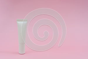 White plastic tube on pink background. Ð¡osmetic bottles for beauty or medicine products