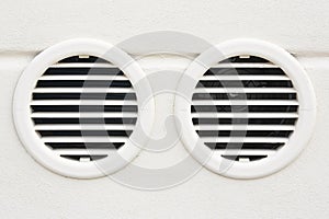 White plastic ventilation grille for internal air conditioner against a plaster wall - Double grille