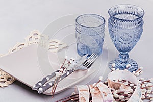 White plate, blue glasses, cutlery and willow