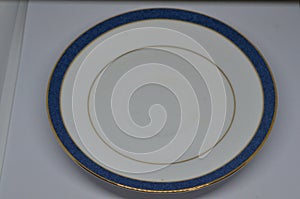 White plate with blue rim sitting on top of a table