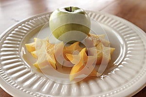 White plate with carambola and fresh apple