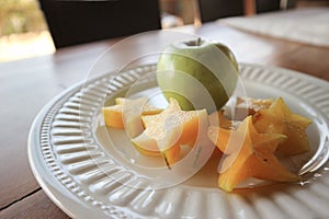 White plate with carambola and fresh apple