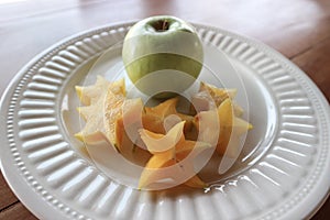 White plate with carambola and fresh apple