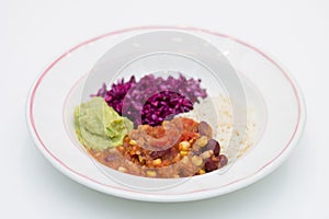 White plate of chili sin carne with red cabbage, guacamole and r photo