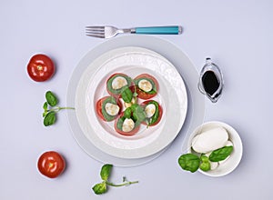 White Plate of Classic Italian Caprese Salad Ripe Tomatoes Fresh Basil Leaf Bowl with Mozarella Cheese Flat Lay Top View Salad and