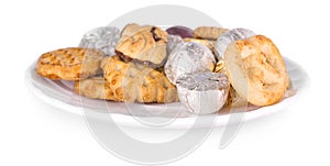 White plate with cookies and candy on white background.