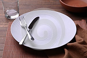 White plate, cutlery and glass of water