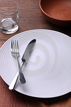 White plate, cutlery and glass of water