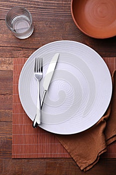 White plate, cutlery and glass of water