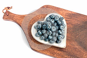 On a white plate, fresh delicious ripe wild blueberry.Isolated on a white background.