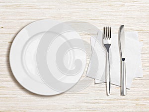 White plate, knife, fork and napkin top view