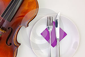 White plate and old violin on the white wooden table