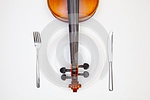 White plate and old violin on the white wooden table