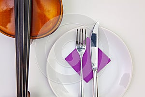 White plate and old violin on the white wooden table