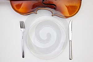 White plate and old violin on the white wooden table