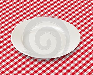 White plate over red picnic tablecloth