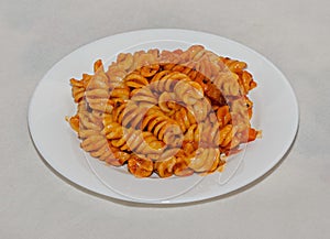 White plate with pasta spaghetti with red tomato sauce,  arrabiata with mushrooms, bacon, parmezan