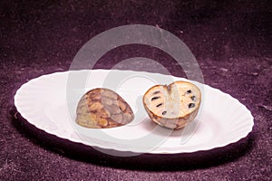 A white plate with a piece of fruit on it