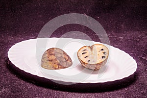 A white plate with a piece of fruit on it