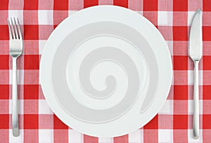 White plate on red and white checkered cloth