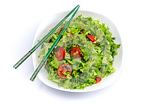 White plate of salad with vegetables isolated on white background. Wooden chopsticks for food