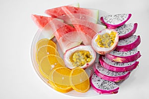 White plate of sliced fruit. Fresh fruits and vitamins. Still life colored summer fruits