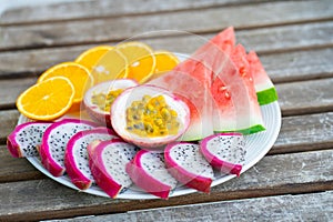 White plate of sliced fruit. Fresh fruits and vitamins. Still life colored summer fruits