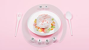 White plate with spoon, fork and Donut decorated icing and sprinkles. Unhealthy Junk Food. Dieting, Healthy Eating, Lifestyle.