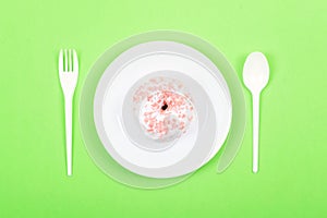 White plate with spoon, fork and Donut decorated icing and sprinkles. Unhealthy Junk Food. Dieting, Healthy Eating, Lifestyle.