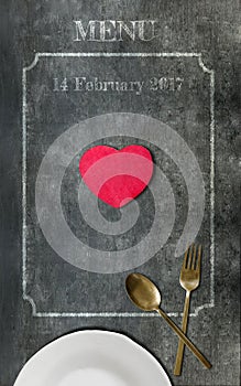 White plate,spoon,fork and red heart on black board