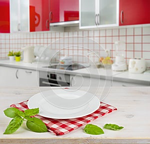 White plate on table over modern kitchen interior background