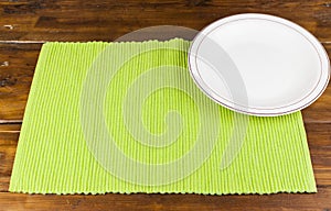 White plate on tablecloth on wood table background