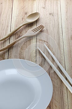 White plate,wooden spoon and chopsticks.