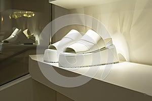 white platform sandals spotlighted on a clean, modern shelf
