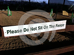 White please do not sit on the fence sign photo