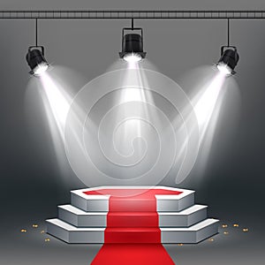 White podium and red carpet illuminated by spotlights