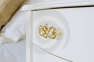 White polished chest of drawers with golden handles. chest of drawers in a classic style. Furniture production, furniture fittings