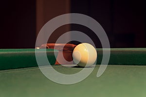 White Pool Ball on Billiard Table Near the Hole