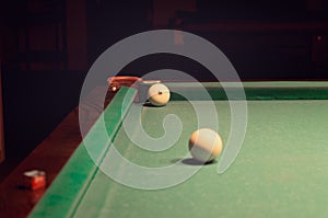 White Pool Ball on Billiard Table Near the Hole